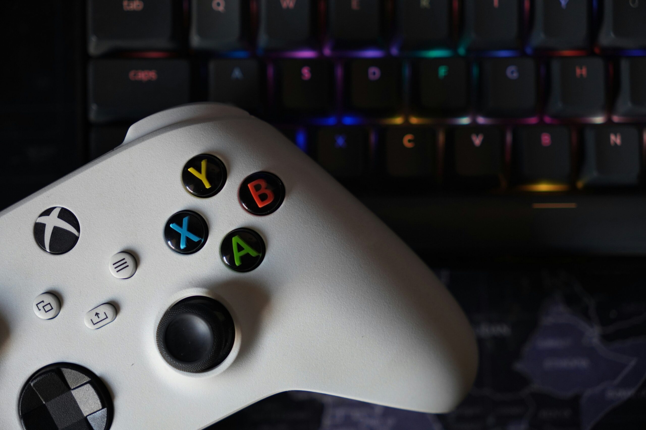 PS5, Xbox Series X e um PC gamer lado a lado com fundo escuro e iluminação RGB