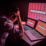 Tela de computador com aviso de ransomware de IA e cadeado digital simbolizando o ataque autônomo JADEPUFFER